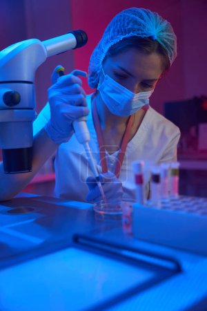 Téléchargez les photos : Employée d'un cryo-laboratoire moderne travaille avec des biomatériaux, dans son travail elle utilise une pipette spéciale - en image libre de droit