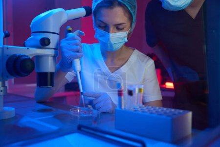Foto de Mujer en un crio-laboratorio moderno trabaja con biomaterial, su colega está cerca - Imagen libre de derechos