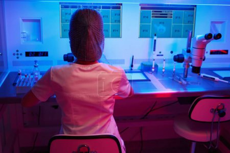 Téléchargez les photos : Femme en uniforme médical travaille dans une salle stérile, équipement moderne dans le laboratoire - en image libre de droit