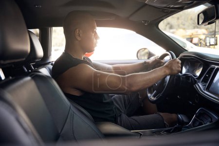 Foto de Hombre seguro de sí mismo prueba de conducción de coche nuevo en el salón, sentado dentro y sosteniendo el volante, imaginando que es el propietario, motivación - Imagen libre de derechos