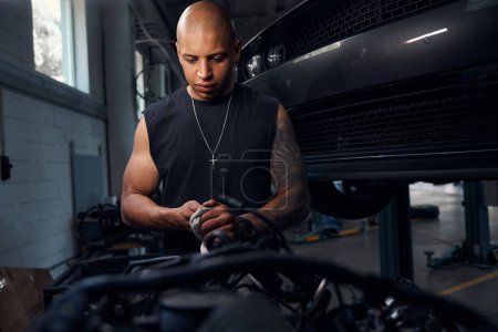 Photo for Concentrated black auto-mechanic cleaning hands and repair tools with cloth in special liquid after the reconditioning, replacement and adjustment of car components - Royalty Free Image