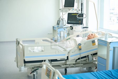 Téléchargez les photos : Dame se trouve sur un lit spécial dans une salle avec du matériel médical pour surveiller les fonctions vitales des patients - en image libre de droit