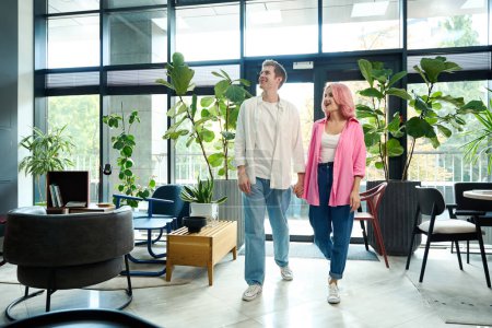Téléchargez les photos : Couple tenant la main marche à travers un salon de créateurs, il ya beaucoup de plantes vivantes dans la chambre - en image libre de droit