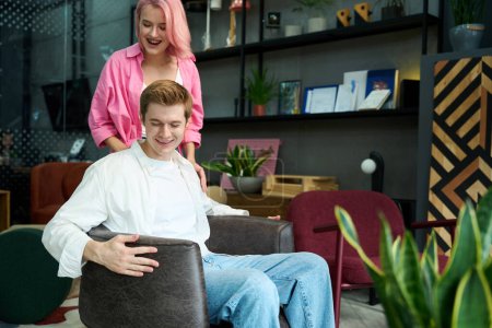 Téléchargez les photos : Jeune femme et l'homme choisissent des meubles pour leur maison dans un salon de meubles design - en image libre de droit