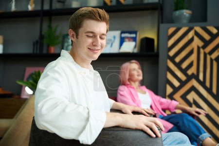 Photo for Smiling woman and a man are sitting in comfortable armchairs, they are choosing furniture for their home - Royalty Free Image