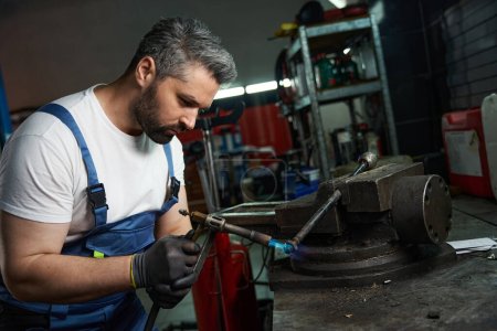 Foto de Retrato de cintura hacia arriba del trabajador de reparación de automóviles enfocado soldadura metal coche parte sujeta en vicio - Imagen libre de derechos