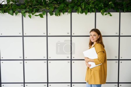 Photo for Young woman freelancer in coworking office area, indoor Young woman freelancer in coworking office area, indoor storage lockers - Royalty Free Image