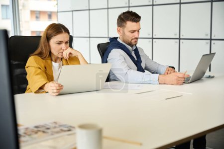 Photo for Upset managers are sitting at their workplaces, people are seated at a large office table - Royalty Free Image