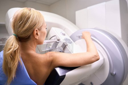 Foto de Vista posterior de la mujer sometida a tomosíntesis mamaria digital en equipos de diagnóstico modernos - Imagen libre de derechos