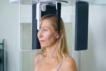 Foto de Retrato de paciente odontológico posicionado en cefalostato observando la distancia durante la radiografía cefalométrica - Imagen libre de derechos