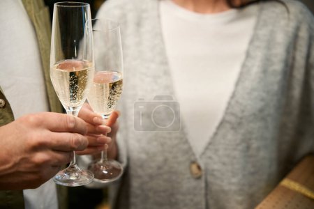 Foto de Mujer irreconocible y hombre celebrando las fiestas de Año Nuevo brindando con una copa de champán - Imagen libre de derechos