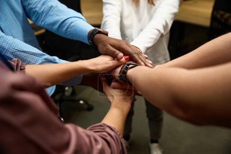 Photo for Multiethnic people putting hands on each other, group of colleagues preparing for new project, putting hands together as symbol of trustful and friendly relations, teambuilding - Royalty Free Image