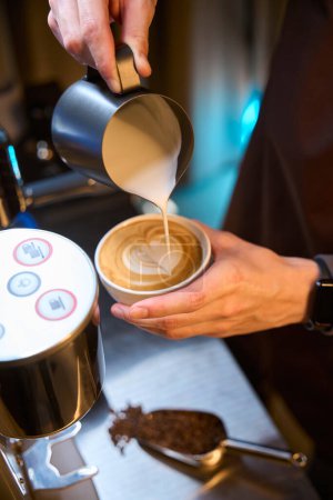 Téléchargez les photos : Barista méconnaissable faisant cappuccino verser du lait pour latte art brassage café dans le café - en image libre de droit