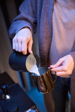 Photo for Unrecognizable woman barista pouring milk from pitcher preparing coffee in coffee shop - Royalty Free Image