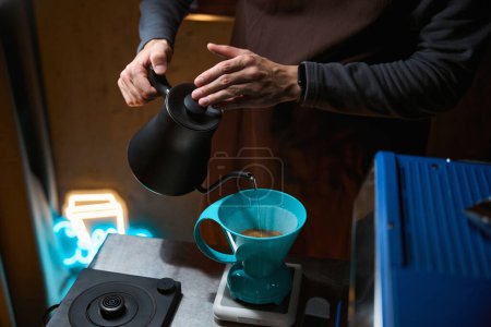 Foto de Barista verter agua caliente sobre el filtro con café molido en el embudo en la cafetería - Imagen libre de derechos