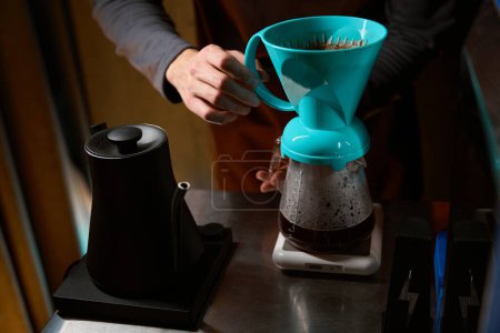 Foto de Cafetera irreconocible preparando café negro en el filtro en la cafetería - Imagen libre de derechos