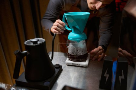 Foto de Barman desconocido elaborando café en filtro usando la escala para la proporción ideal en la cafetería - Imagen libre de derechos