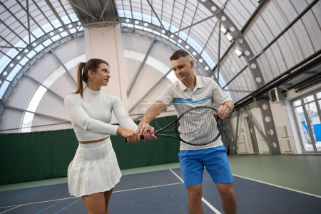 Téléchargez les photos : Fit femme avec entraîneur homme entraînement tennis se concentrant sur l'agilité et l'amélioration des compétences avec des raquettes de tennis - en image libre de droit