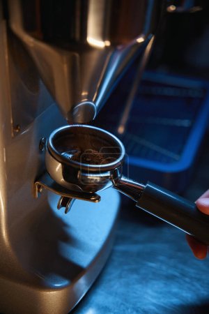 Foto de Barista irreconocible moliendo granos de café usando máquina de café - Imagen libre de derechos