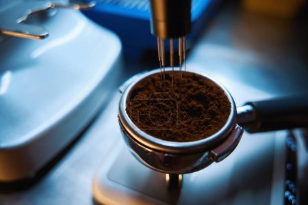 Foto de Nivelación de proceso de café en portafilter con distribuidor de polvo especializado y báscula de pesaje en cafetería - Imagen libre de derechos