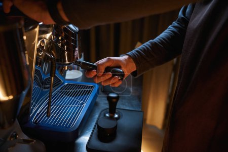 Téléchargez les photos : Barista mains tenant portafilter et faire du café aromatique frais en utilisant une cafetière moderne - en image libre de droit