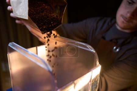Téléchargez les photos : Barista broyage des grains torréfiés en poudre brassage café moulu frais dans le café - en image libre de droit