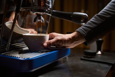 Foto de Manos de barista haciendo café con cafetera espresso en la cafetería - Imagen libre de derechos
