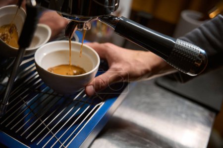 Téléchargez les photos : Barista versant espresso de la machine à café dans le café - en image libre de droit