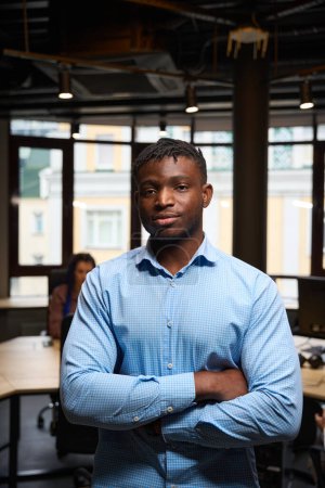 Photo for African American man folding hands on chest and looking at camera with serious face expression, young and confident man as high-qualified specialist working in it sphere - Royalty Free Image
