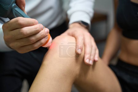 Photo for Close up photo of female undergoing laser therapy for reduction of swelling and inflammation on knee - Royalty Free Image