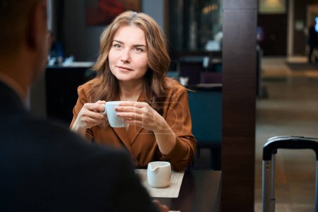Foto de De cerca la foto de la señora con una taza de café en las manos sentadas a la mesa en el restaurante - Imagen libre de derechos