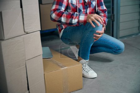Photo for Man twisted his knee while transporting things in cardboard boxes - Royalty Free Image