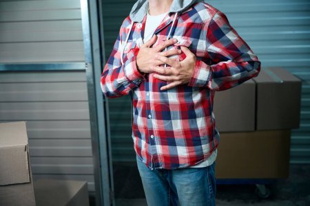 Téléchargez les photos : Un homme a souffert d'une crise cardiaque alors qu'il transportait des choses dans un entrepôt - en image libre de droit
