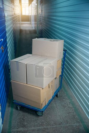 Photo for Group of cardboard boxes with moving items in a storage unit - Royalty Free Image