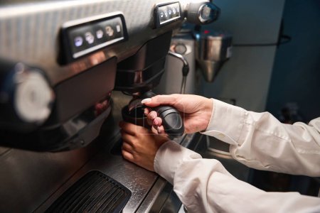 Foto de Barista en una blusa blanca prepara café en una máquina de café, utilizando equipos modernos - Imagen libre de derechos
