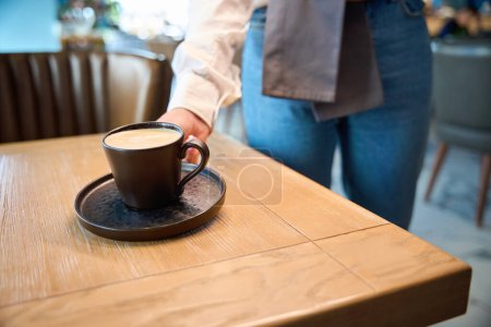 Photo for Waiter serves coffee for one person, in a cappuccino cup - Royalty Free Image