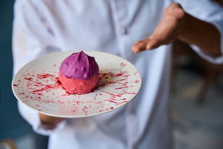 Foto de Chef presenta un postre de fruta original, un pastel rosa se encuentra en un plato minimalista - Imagen libre de derechos