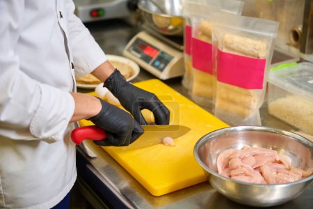 Téléchargez les photos : Cuire des coupes de filet de poulet sur une planche à découper, des produits de qualité sont utilisés - en image libre de droit