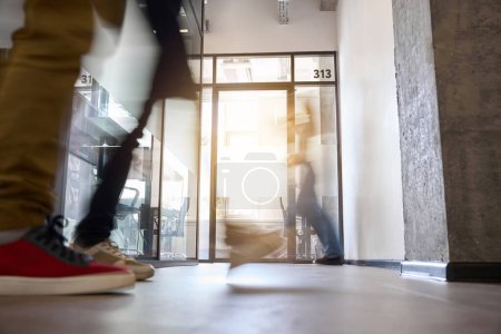 Photo for Movement of people in hall of office building near the office number 313, boss office, meeting room or lounge room with transparent glass door, coworking space - Royalty Free Image