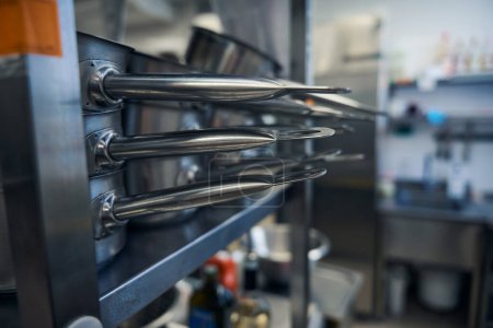 Téléchargez les photos : Poêles à frire brillantes et polies sur des étagères de cuisine, plats fabriqués à l'aide de technologies modernes - en image libre de droit