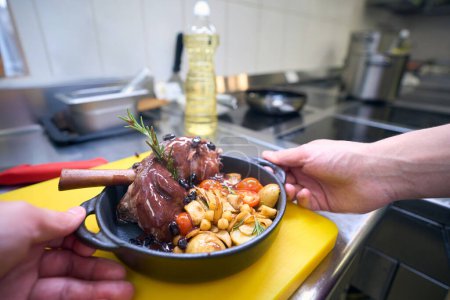 Foto de Cocinero preparado la carne con verduras y salsa, utiliza productos de calidad - Imagen libre de derechos