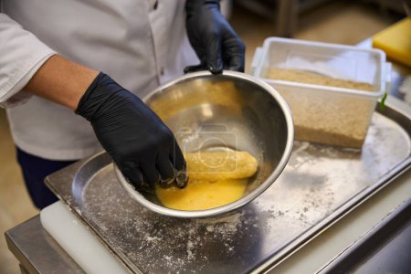 Foto de Chef panes una chuleta de Kiev en pan rallado, trabaja en una bandeja de metal - Imagen libre de derechos