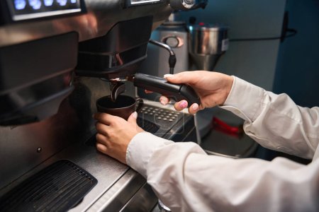 Téléchargez les photos : Barista prépare le café dans une machine à café, en utilisant un équipement moderne - en image libre de droit