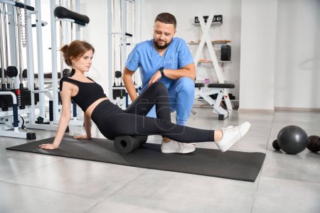 Photo for Physiotherapist instructor works with a patient in the gym, special gadgets are used - Royalty Free Image