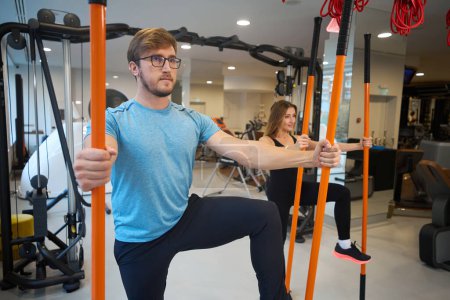 Foto de Las personas en el gimnasio realizan ejercicios de equilibrio, utilizan palos deportivos especiales - Imagen libre de derechos