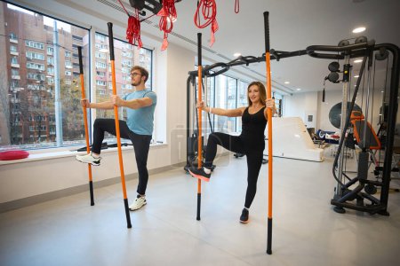 Téléchargez les photos : Les clients du centre de bien-être effectuent des exercices d'équilibre en utilisant des bâtons de sport spéciaux - en image libre de droit