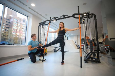 Photo for Physical exercises under the supervision of an instructor in a rehabilitation center, using special sports sticks - Royalty Free Image
