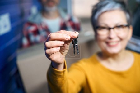 Photo for Keys to a luggage storage room in the hands of a woman with a short haircut - Royalty Free Image