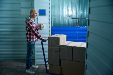 Téléchargez les photos : Homme chauve transportant des boîtes en carton avec des choses dans une salle de stockage - en image libre de droit