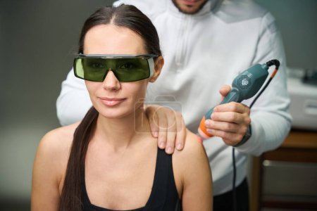 Photo for Female undergoing laser therapy for reduction of swelling and inflammation on arm - Royalty Free Image